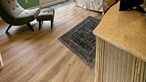 Un dormitorio con una cama, una silla, un escritorio y una televisión.