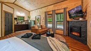 A log cabin interior with a living area, fireplace, television, and kitchen. - Cozy New Cabin I King Bed I Hot Tub I Fire Pit I Fast WiFi (Sevierville)