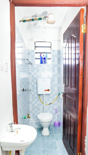 A small bathroom with a toilet, sink, and shower. - Lux Suites Tara Smart Homes Naivasha (Naivasha)