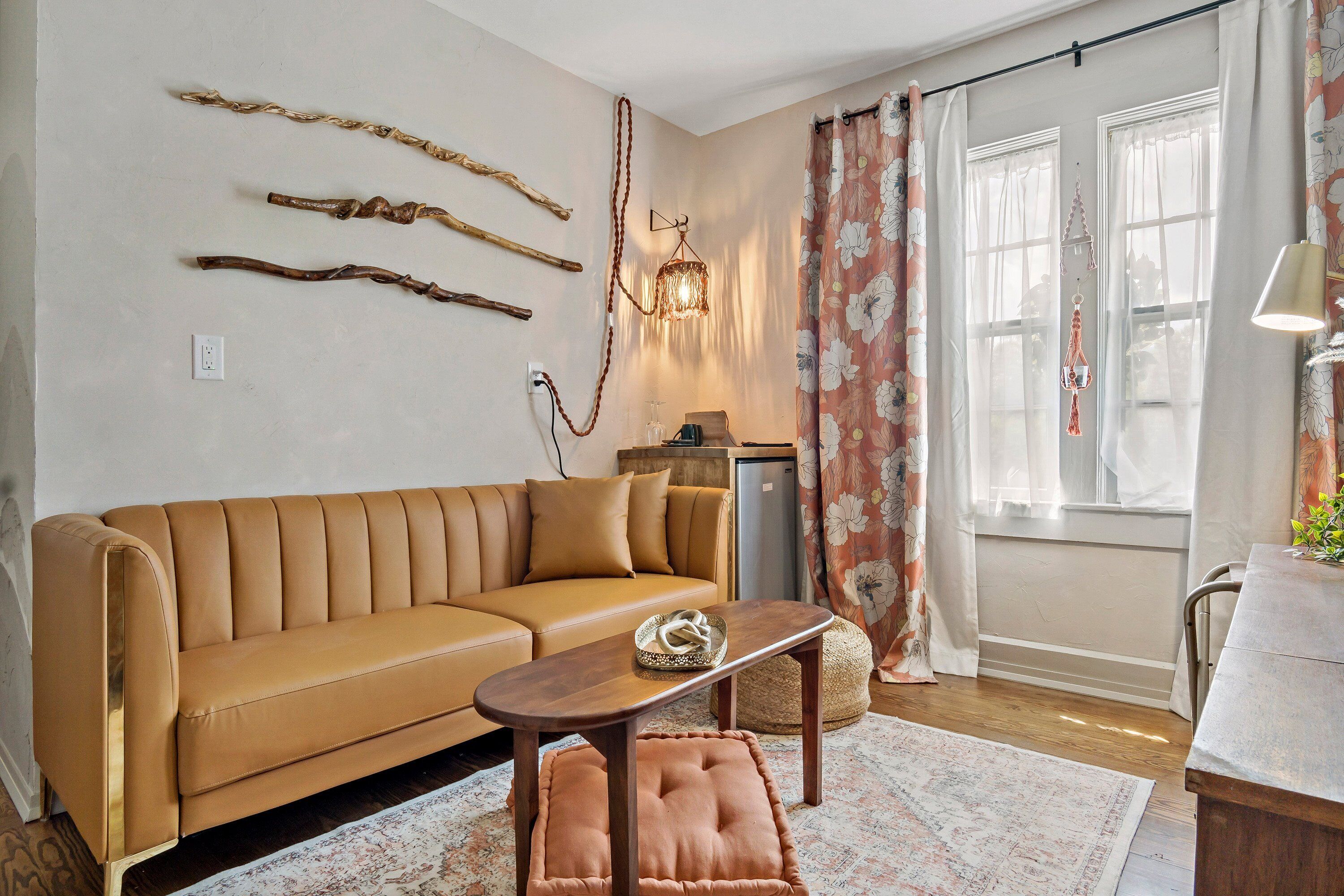 A living room with a tan sofa, a wooden coffee table, and a patterned rug.