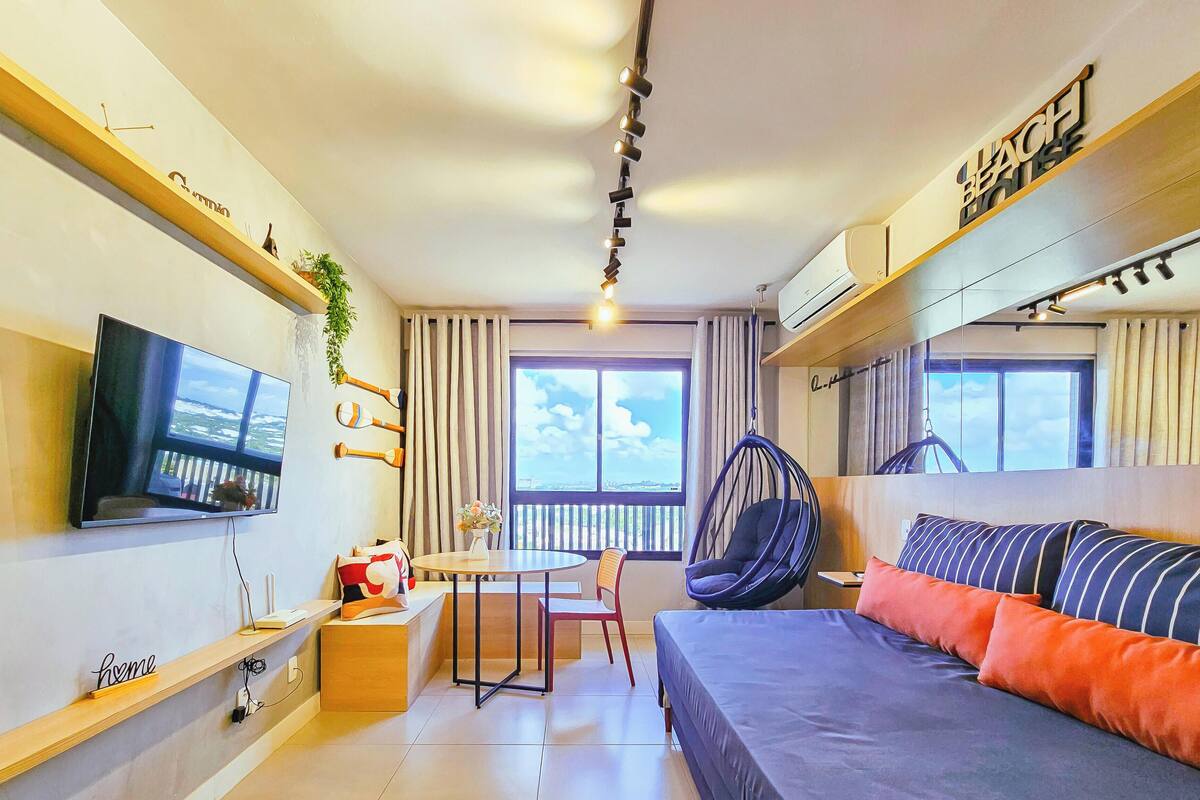 Una habitación pequeña con cama, televisión, mesa de comedor y una silla.