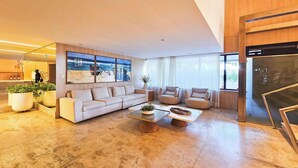 Una sala de estar moderna con un sofá, sillones, una mesita de centro y un ventanal grande.