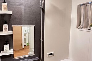 A bathroom with a mirror, a shower, and a window with curtains. - Tabitime Oimasato Kiki 7min to Namba / 2min to Station /70 sqm house (Osaka)