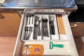 A kitchen drawer with utensils, a grater, and a bear-shaped kitchen tool. - Tabitime Oimasato Kiki 7min to Namba / 2min to Station /70 sqm house (Osaka)