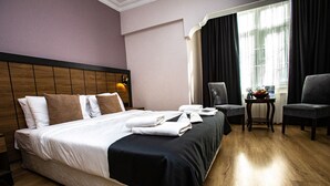 A hotel room with a large bed, two chairs, a small table with a fruit bowl, and a window with curtains. - Comfort Home Taksim (Istanbul)