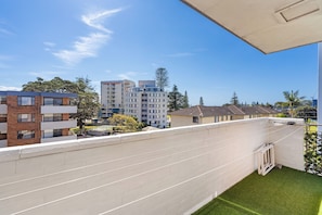 A residential building with multiple floors, balconies, and a clear sky.