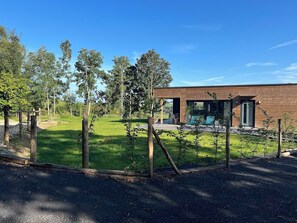 A modern building with a brick exterior, surrounded by a well-maintained lawn and trees.