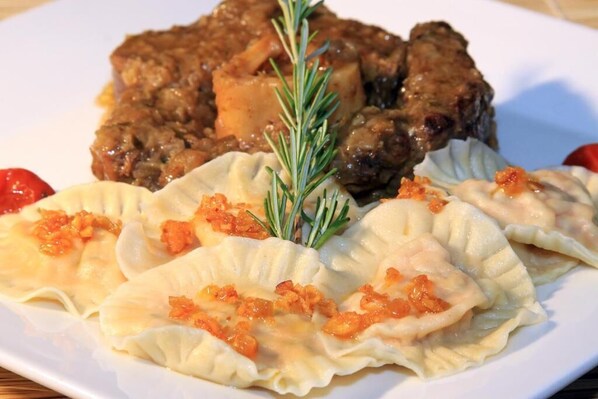 A plate of dumplings with a garnish of rosemary and a side of meat. - Praiagogi Boutique Pousada (Maragogi)