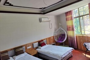 A hotel room with two beds, a hanging chair, and a window with curtains. - nqkz (Wuyuan)