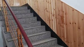 Una escalera de granito con barandilla de madera.