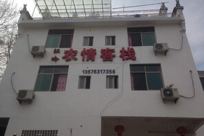 A building with a sign that reads 'Agricultural Customer Service' and a phone number. - nqkz (Wuyuan)