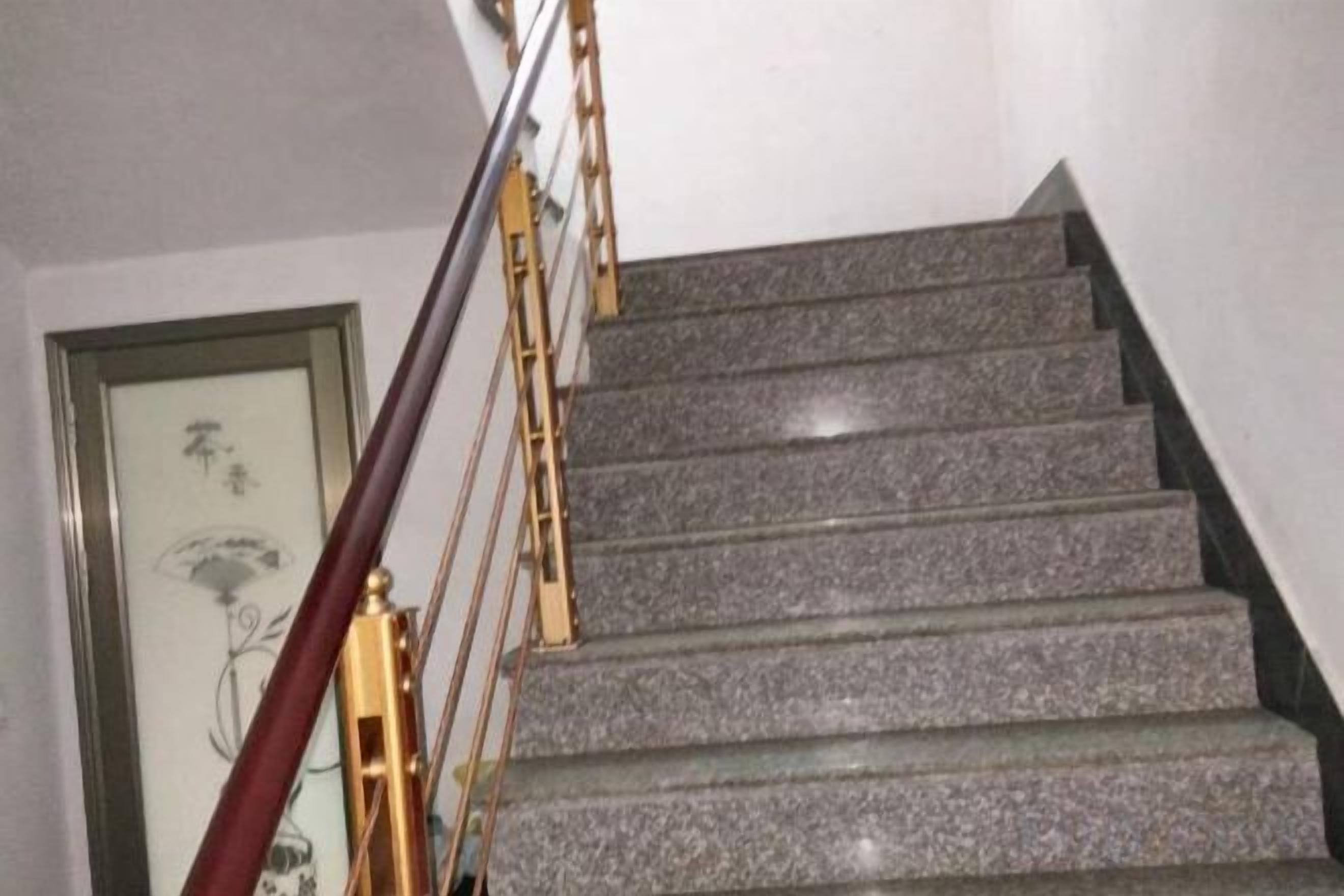 A staircase with a handrail and a framed picture on the wall.