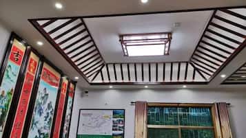 A room with a sloped ceiling, recessed lighting, a skylight, and a window with curtains.