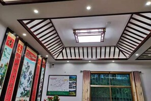 A room with a sloped ceiling, recessed lighting, a skylight, and a window with curtains. - nqkz (Wuyuan)
