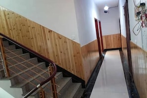A staircase with wooden handrails and a tiled floor leading to a landing. - nqkz (Wuyuan)