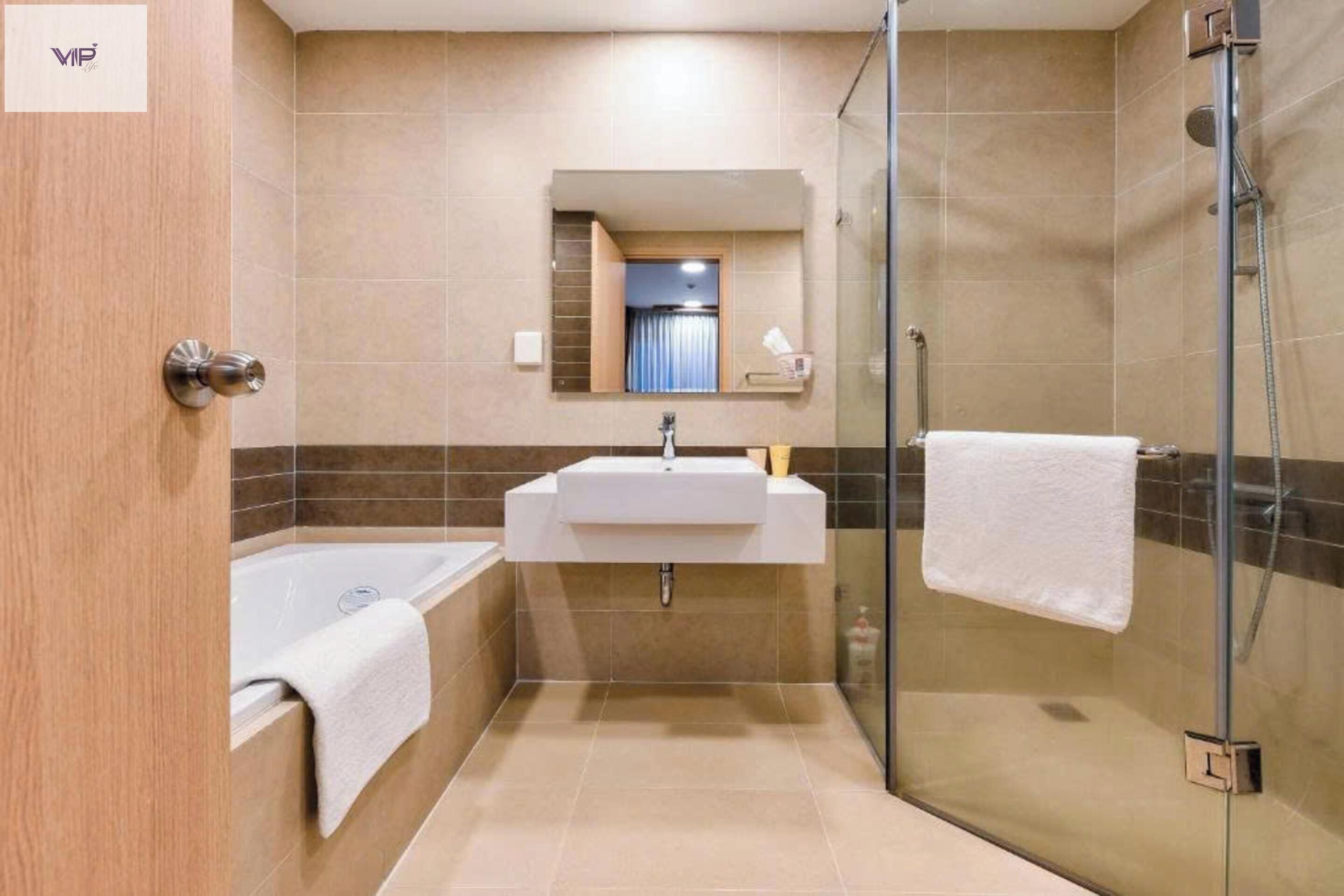 Een moderne badkamer met een douchecabine van glas, een vrijstaand bad en een wastafel met spiegel erboven.
