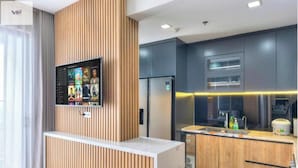 Una cucina moderna con TV integrata, elementi in legno e un design elegante.