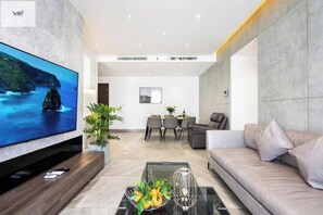 Relax in this stylish living room with a large flat-screen TV, comfortable sofa, and dining area for four.