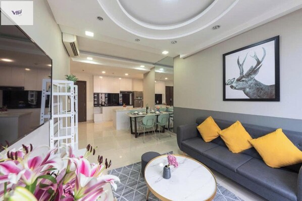 A modern living room with a grey sofa, yellow cushions, a marble coffee table, and a framed deer artwork on the wall. - Landmark 81 Skyline VIP (Ho Chi Minh City)