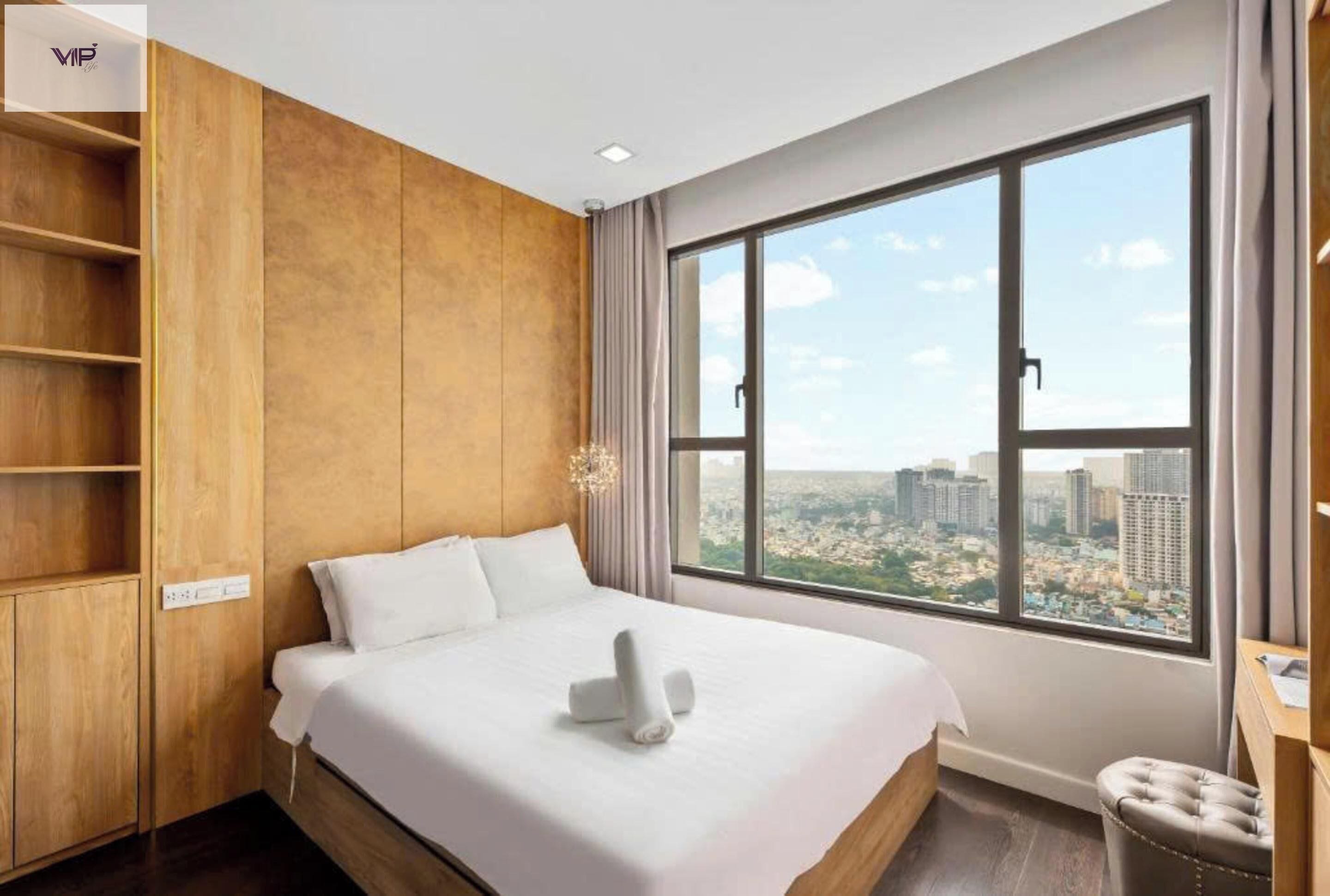 Une chambre d’hôtel avec un grand lit, une vue sur la ville et une armoire en bois.