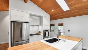 Une cuisine moderne équipée d’un réfrigérateur en acier inoxydable, d’une cuisinière à gaz et d’un évier.