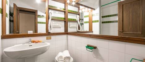 A bathroom with a white sink, a toilet, and a mirror with wooden frames.