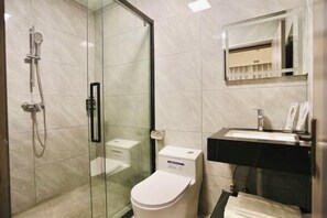 A modern bathroom with a glass shower enclosure, a white toilet, and a black sink with a mirror above it. - Xinghe Business Hotel (Luhe)