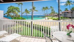 A balcony with a view of a beach, palm trees, and a clear sky. - Kiahuna Plantation Resort 190 Ocean View 1 Bedroom (Koloa)