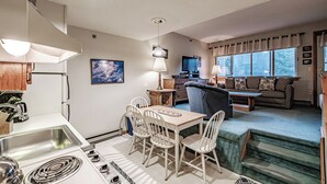 A compact living space with a dining area, kitchen, and seating area. - One Bedroom Cascades A-24, direct access from outside, sleeps 6 (Newry)