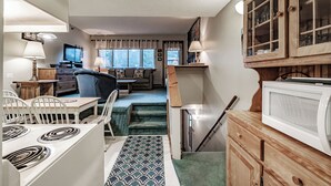 A compact kitchen with a stove, microwave, and wooden cabinets. - One Bedroom Cascades A-24, direct access from outside, sleeps 6 (Newry)