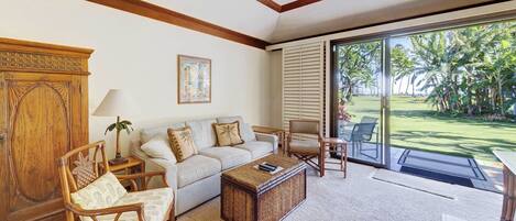 A living room with a sofa, chairs, a coffee table, and a wooden cabinet.