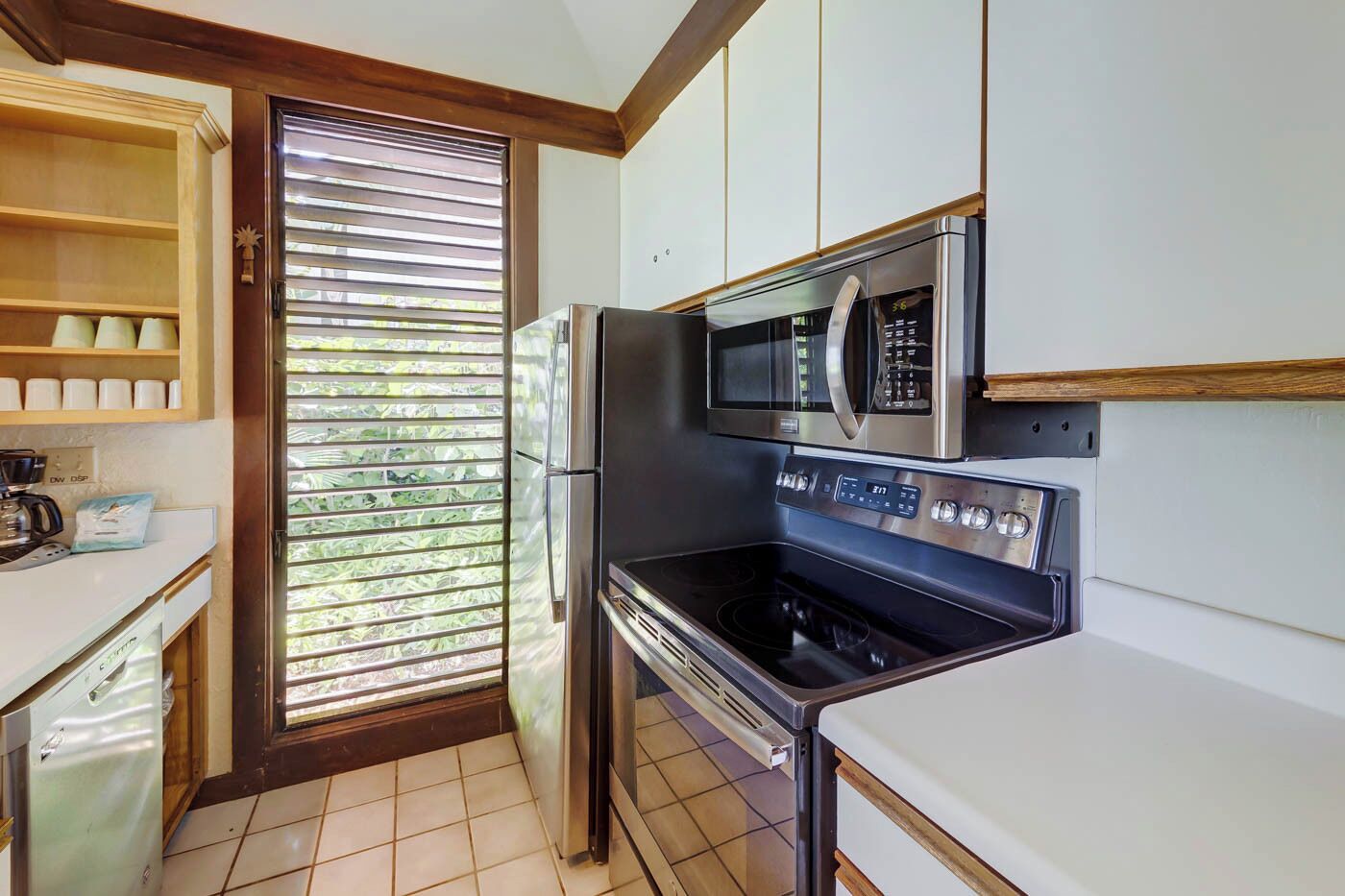 A compact kitchen with a built-in microwave, oven, and refrigerator.