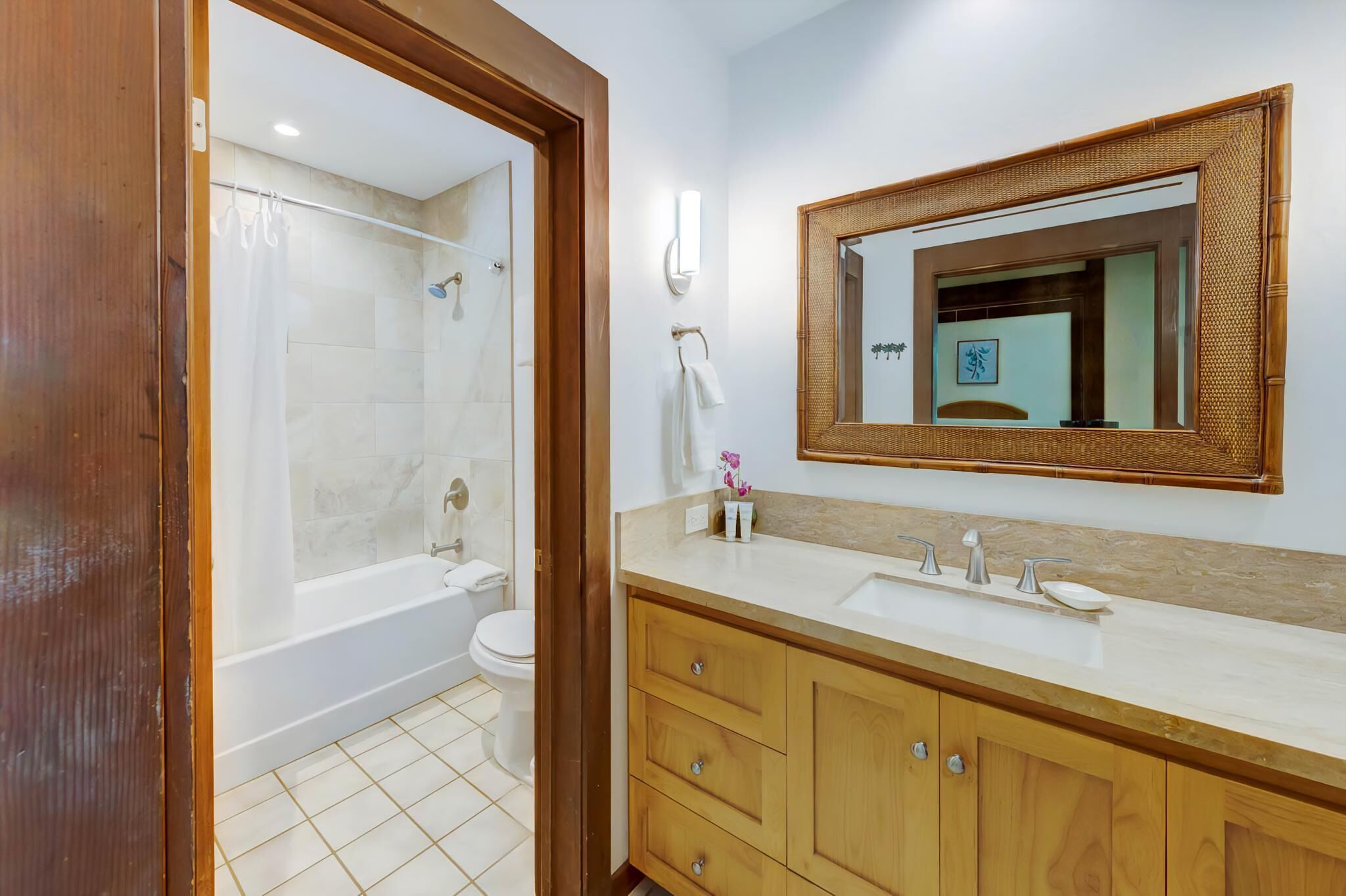 A bathroom with a bathtub, toilet, and vanity with a mirror.