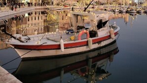 A waterfront area with a docked boat, buildings, and a clear sky. - Ground floor villa T2 air-conditioned, 45 m², with garden (La Ciotat)