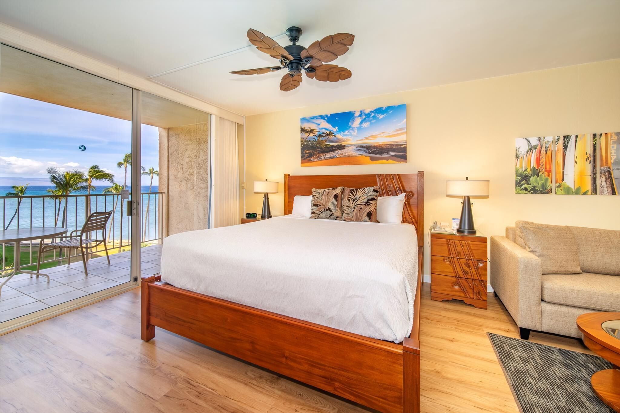 Um quarto espaçoso com uma cama grande, varanda com vista para o mar e ventoinha no teto.