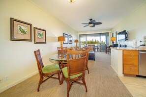 A dining area with a round table, chairs, and a ceiling fan.