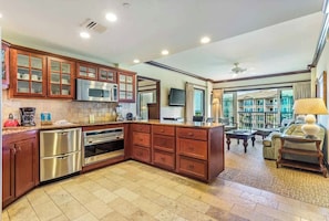 Una cocina moderna con electrodomésticos de acero inoxidable, armarios de madera y una isla grande.