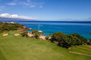 A golf course with a view of the ocean and a lighthouse.