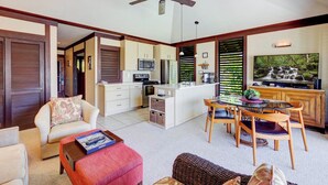A spacious living area with a dining table, sofas, and a kitchen in the background.