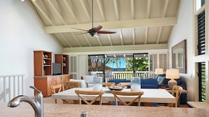 Une cuisine spacieuse dotée de plans de travail en granit, un coin repas avec une table et des chaises, un ventilateur de plafond et une vue sur l’extérieur.