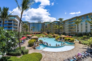 Ein Resort mit einem zentralen Swimmingpool, mehreren Balkonen und üppiger Bepflanzung.