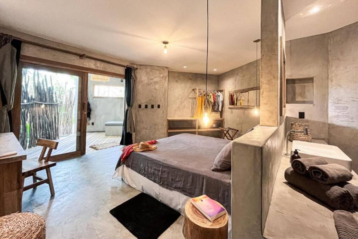 Une chambre moderne avec un grand lit, un bureau et une salle de bain équipée d’une baignoire.