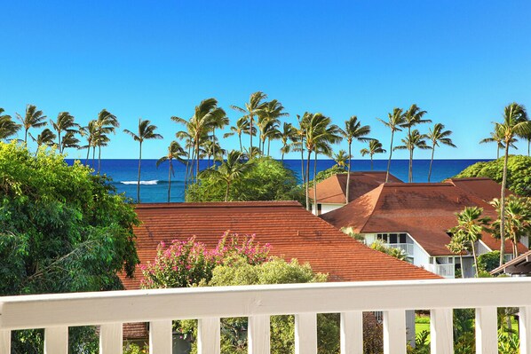 A coastal property with multiple buildings, palm trees, and a view of the ocean.