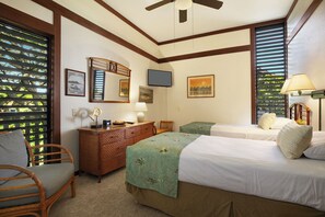 Une chambre d’hôtel avec deux lits, une commode en bois, une chaise et un ventilateur de plafond.