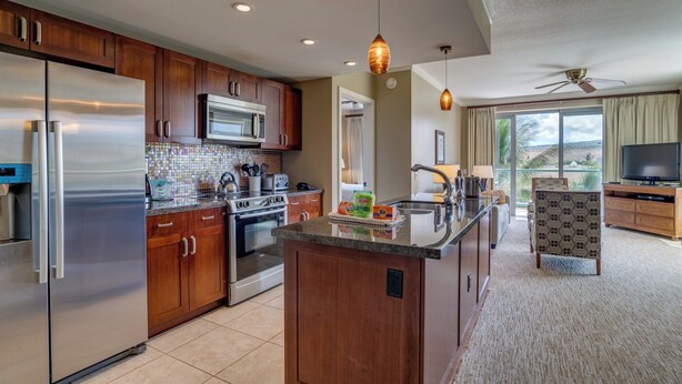 A modern kitchen with stainless steel appliances, wooden cabinets, and a central island. - Honua Kai Resort View 2 Bedroom (Lahaina)