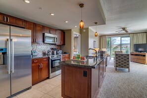 A modern kitchen with stainless steel appliances, wooden cabinets, and a central island.