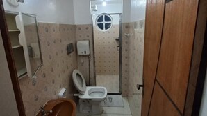 Un baño pequeño con inodoro, lavamanos y espejo.