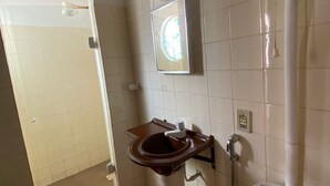 Een badkamer met toilet, wastafel en spiegel.