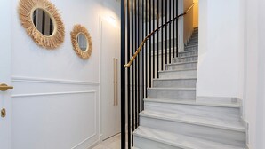 A staircase with white marble steps and a black railing. - Genteel Home Casa Lagar III (Seville)