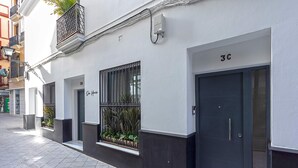 A building with a dark door labeled "3C" and a window with metal bars. - Genteel Home Casa Lagar III (Seville)